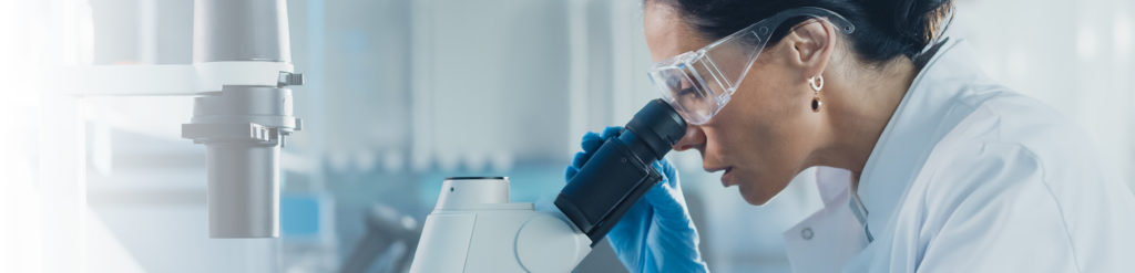 scientist looking through microscope